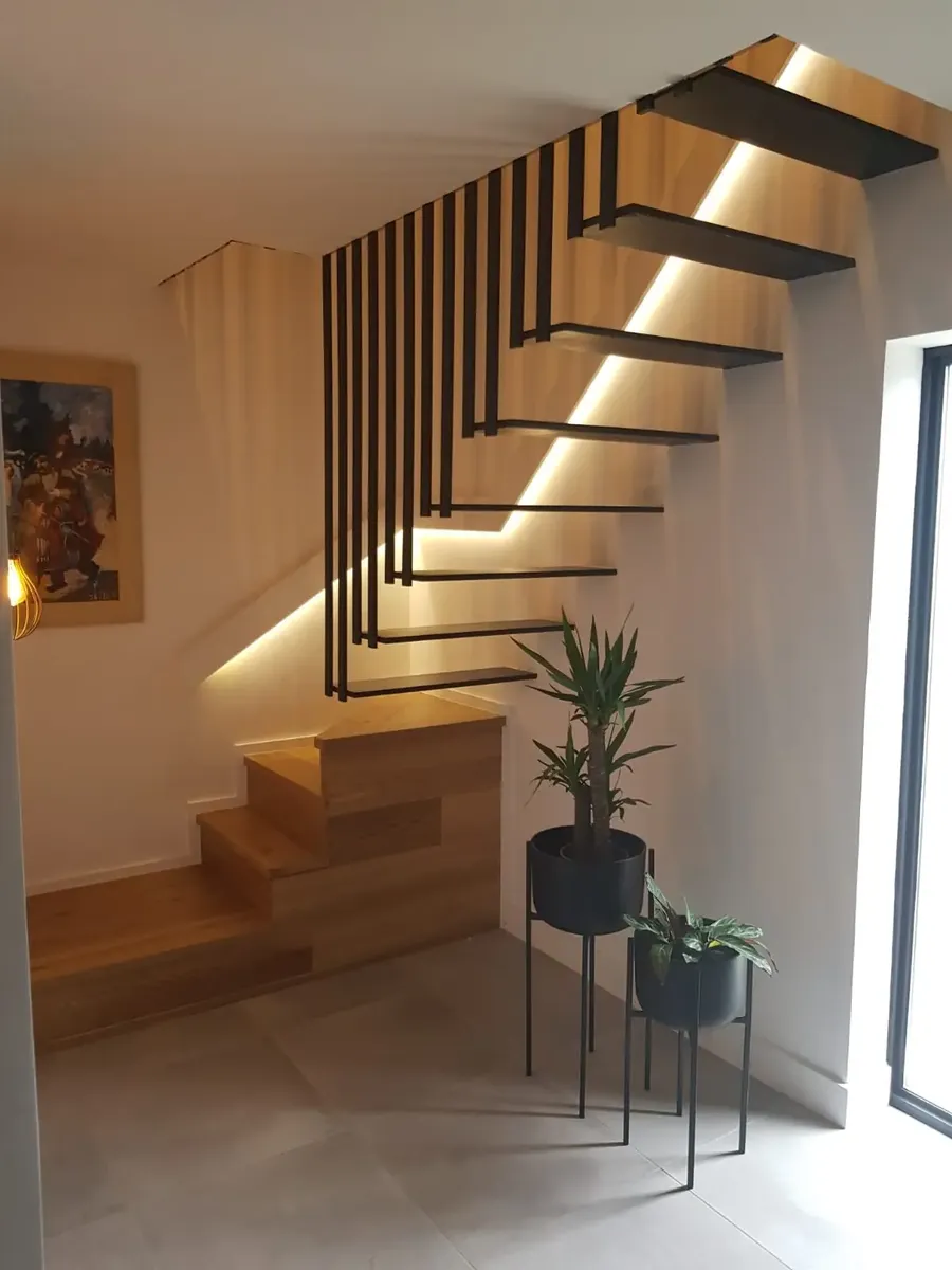 Floating timber staircase with steel balustrade and step lighting in a Wood Green house