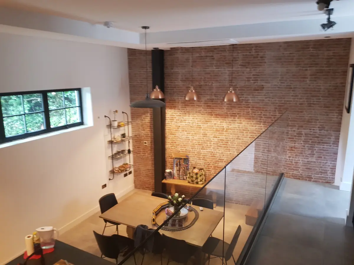 Dining area with exposed brick and a glass balustrade